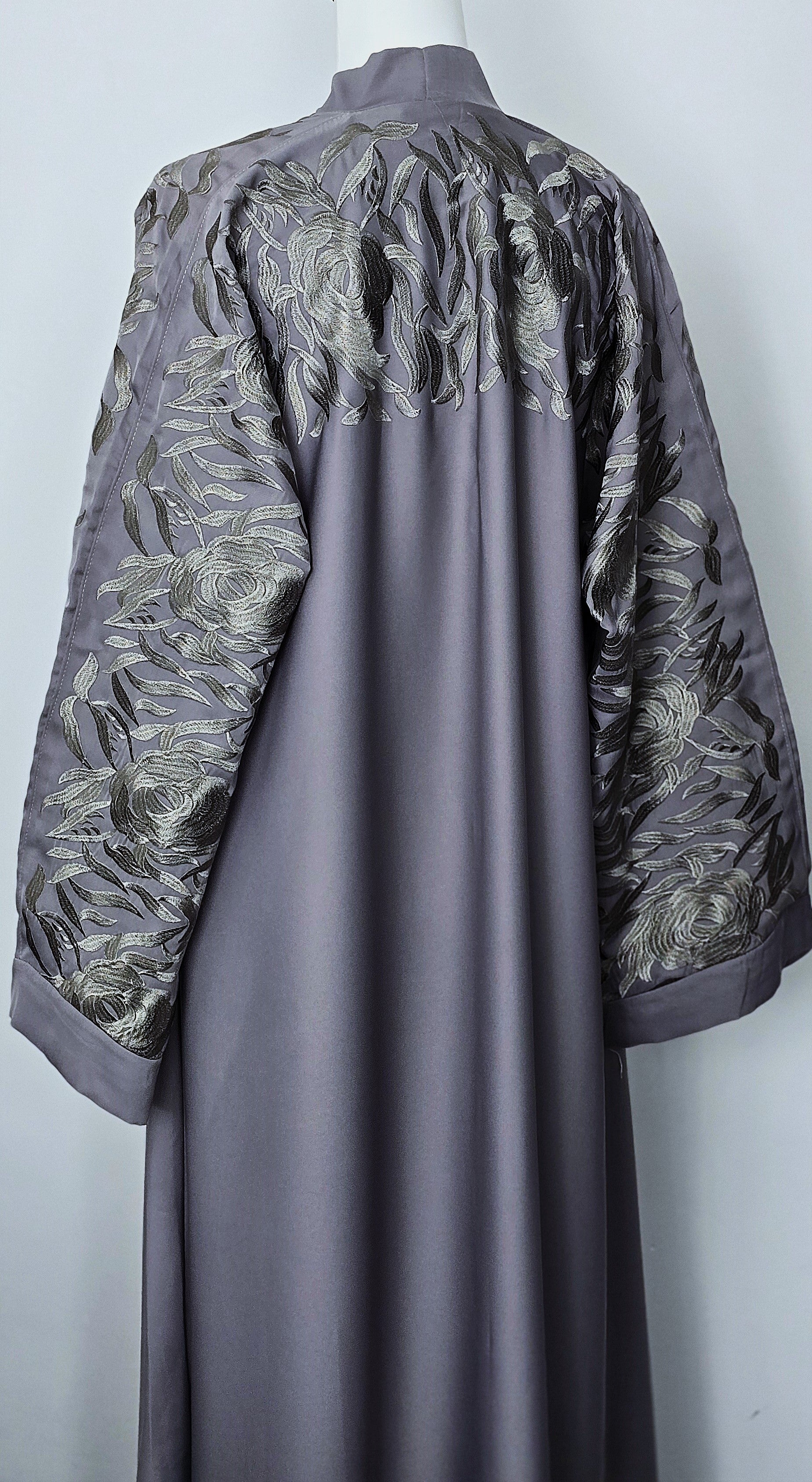 Long, dark gray dress with floral embroidery on a white background